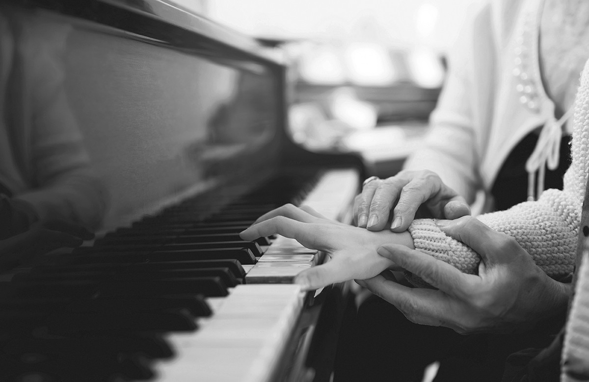 experienced hand of the old music teacher helps the child  pupil