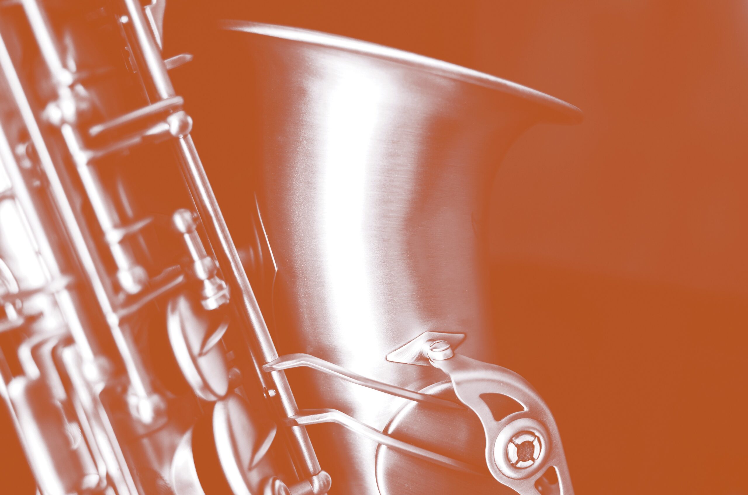 Detail of alto saxaphone, over black background.